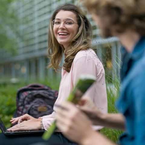 UNH graduate business professional sitting outside on bench